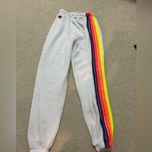White 5-stripe Aviator Nation sweatpants with neon strips.